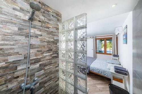 a bathroom with a stone wall and a shower at Beach Apartment 11 in Cala d´Or