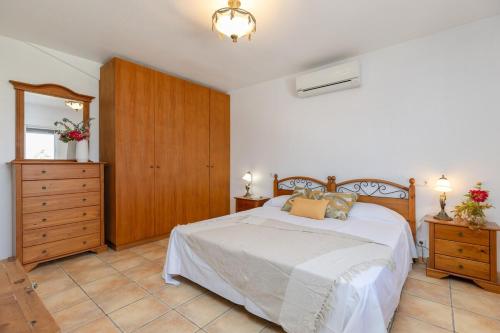 a bedroom with a bed and a dresser and a mirror at Fidalsa Golf Beach in Ciudad Quesada
