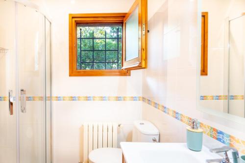a bathroom with a toilet and a sink and a window at Ca la Irene II in Begur