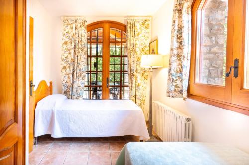 a bedroom with a white bed and a window at Ca la Irene II in Begur