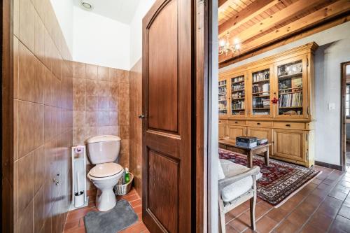 a bathroom with a toilet and a wooden door at Séjour dans ferme de 1876 in Marignier