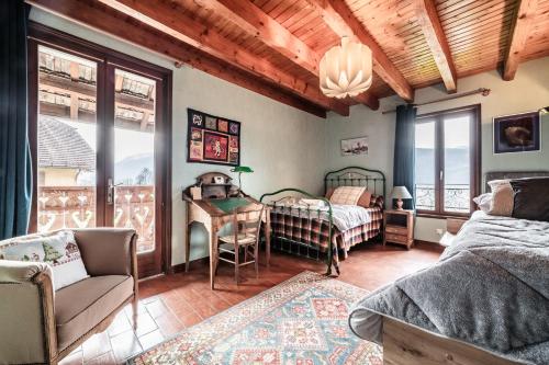 a bedroom with a bed and a desk in a room at Séjour dans ferme de 1876 in Marignier