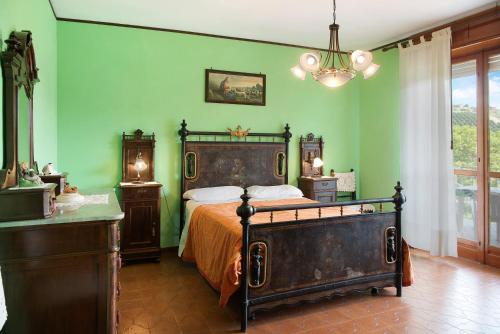a bedroom with a bed and green walls at Appartamento Glicine in Cisterna dʼAsti