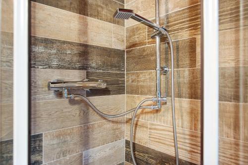 a shower in a bathroom with a wooden wall at Maison Core' in Fontainamore