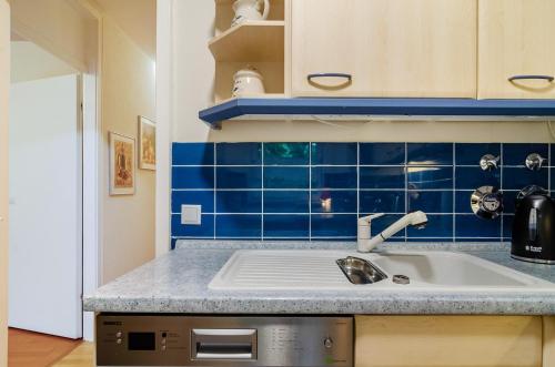 a kitchen with a sink and a blue tiled wall at Ferienwohnung Schmälzle in Braunlage