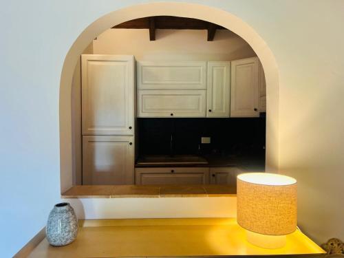 a kitchen with white cabinets and a table with a lamp at Villa Sole con piscina privata in Cuile Pazzoni