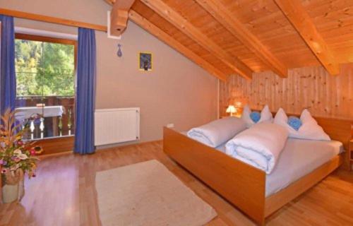 a bedroom with a bed and a large window at Fillerhof in Villnoss