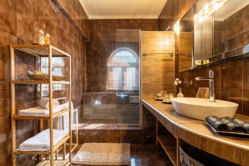 a bathroom with a sink and a shower at Afentika Grand Flat in Archangelos