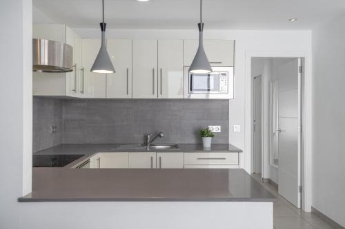 a kitchen with white cabinets and a sink at Apartamento Princesa Teguise in Tías