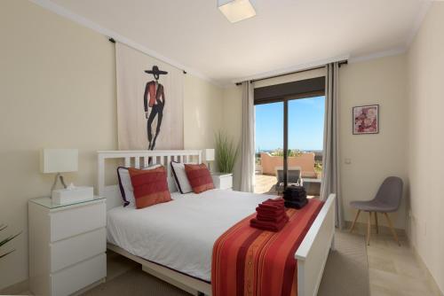 a bedroom with a white bed and a balcony at Casares Beach luxe penthouse in Casares