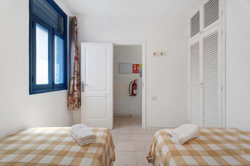 a bedroom with two beds and a window at Apartamentos Playa Azul - 7 in Vallehermoso