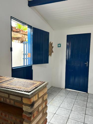 a kitchen with a blue door and a tile floor at Suite Canoa azul 1 in Aracati