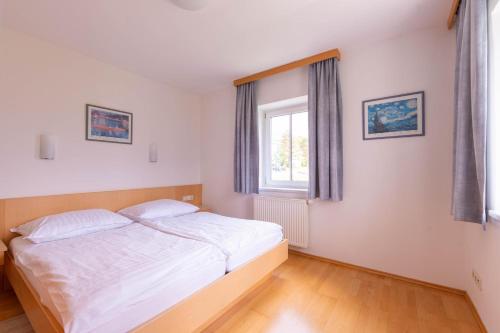 a bedroom with a white bed and a window at Appartment Isabelle in Lake Pressegg