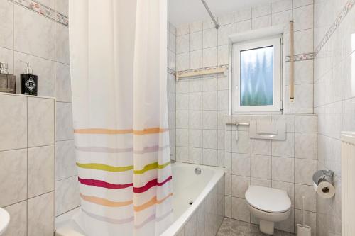 a bathroom with a tub and a toilet and a sink at Residenz Malscher Aue in Malsch
