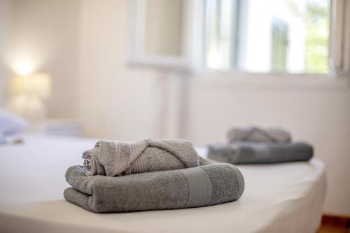 a pile of towels sitting on top of a bed at Sa Sivina in Cala en Bosc