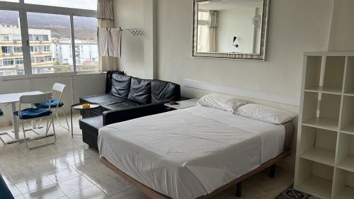a bedroom with a bed and a chair and a mirror at Mirador los molinos in San Bartolomé