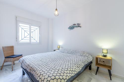 a bedroom with a bed and a window and a chair at Calpe Bay in Calpe
