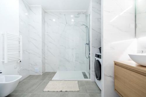 a white bathroom with a shower and a sink at Ptm riverview T2 luxe 2nd floor in Portimão