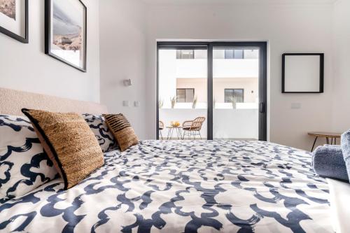 a bedroom with a large bed and a balcony at Ptm riverview T2 luxe 2nd floor in Portimão