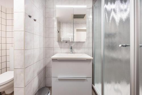 a white bathroom with a sink and a shower at Ferienwohnung Schmolei in Kronprinzenkoog
