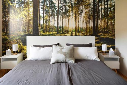 a bedroom with a bed with a forest wallpaper at Am Sommerrain in Elzach