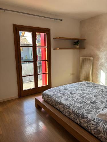 a bedroom with a bed and a sliding glass door at La Masera sul Torrente By Immobilux in Mori