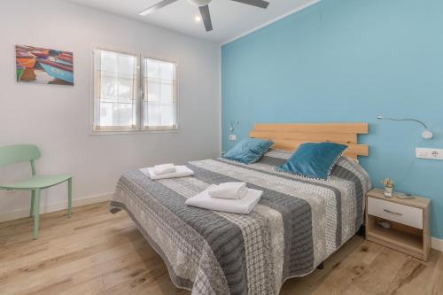 a bedroom with a large bed with blue pillows at Melissa Apartment in Alaior