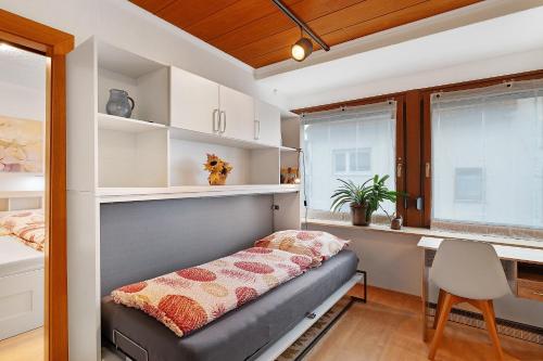 a bedroom with a bench and a desk and windows at Ferienwohnung Eva Maria in Pforzheim