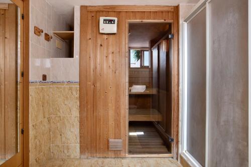 a bathroom with a shower with a wooden door at Casa Torremuelle in Benalmádena