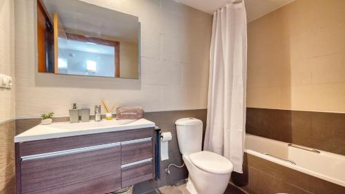 a bathroom with a sink and a toilet and a tub at Costacabana - Apartment Dali in Lloret de Mar