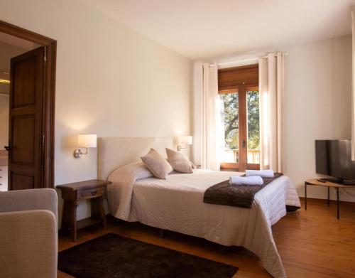 a bedroom with a white bed and a window at Petit Castanyer in Viladrau