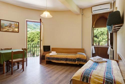 a bedroom with two beds and a desk and a balcony at Appartamento Bilocale Moneglia 38 in Moneglia