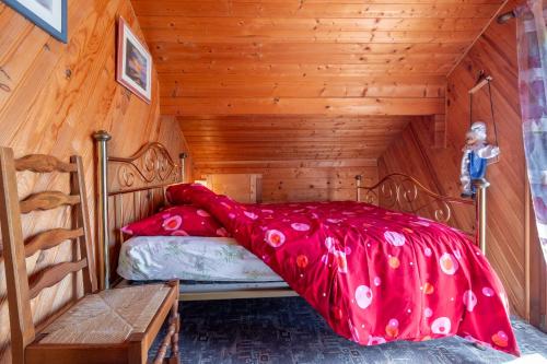 a bedroom with a bed in a wooden room at Chalet de Monique in Le Val-dʼAjol