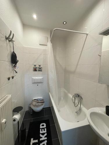 a bathroom with a tub and a toilet and a sink at Das grüne Haus in Finsterwalde