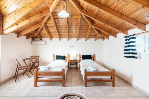 a room with three beds and wooden ceilings at Blue Pearl in Lachania