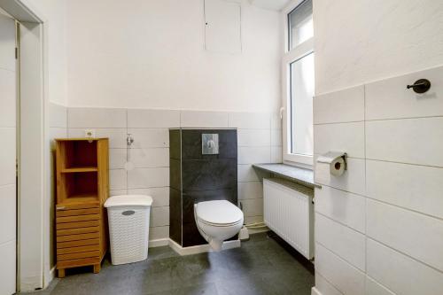 a white bathroom with a toilet and a window at Lisbeth in Sankt Wendel
