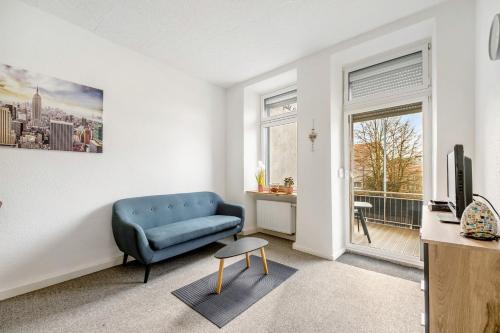 a living room with a blue couch and a window at Lisbeth in Sankt Wendel