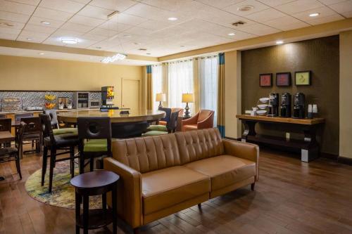 a waiting room with a couch and a bar at Park Inn by Radisson, Columbus State University Area in Columbus