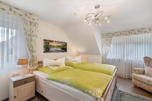 a bedroom with a bed and a chandelier at Haus Haag Enzklösterle in Enzklösterle
