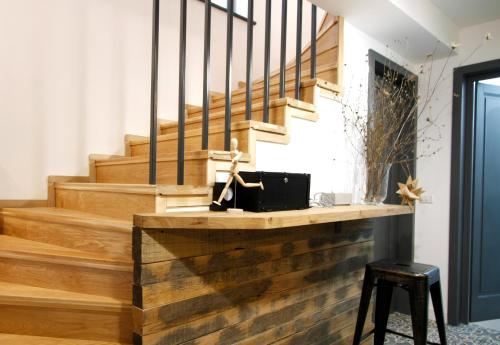 a wooden staircase with a wooden rail and a stool at The Pines Boutique Villa in Braşov