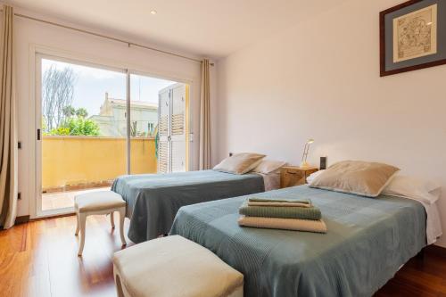 two beds in a room with a large window at Casa con jardín próxima a Barcelona in Sant Andreu de Llavaneres