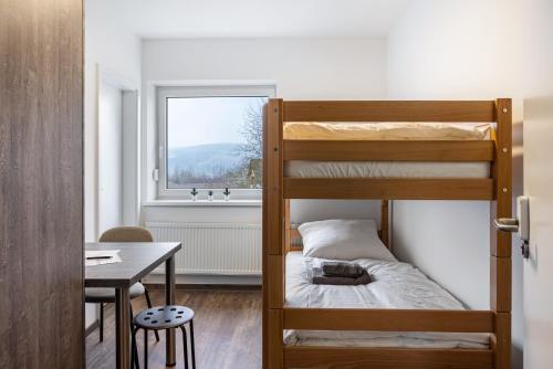 a small room with bunk beds and a table at Haus Fuldablick in Rotenburg an der Fulda