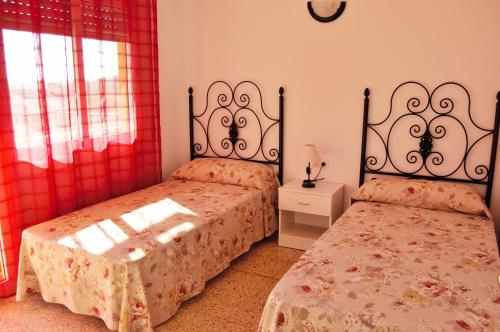 リョレート・デ・マルにあるVilla Dorisのベッドが2つあり、壁に時計がある寝室