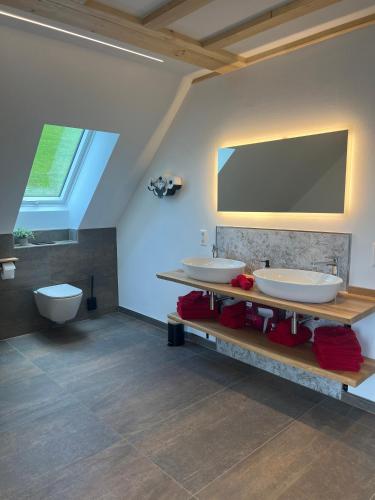 a bathroom with two sinks and a flat screen tv at Ferienhaus am Kapellenhof in Triberg