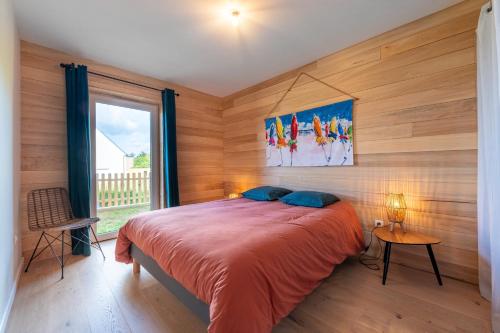 a bedroom with a large bed with wooden walls at Gite Familiale ty laouen in Sarzeau