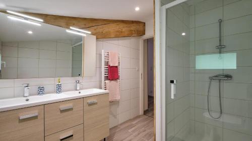 a bathroom with a sink and a glass shower at Maison - Chez Louisette in Espezel