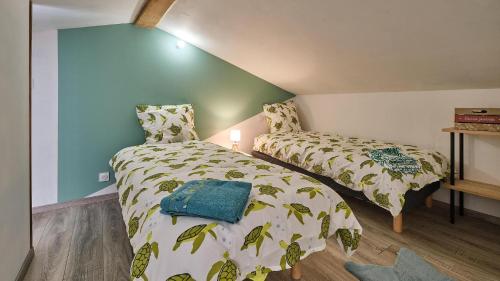 a bedroom with two beds and a blue wall at Maison - Chez Louisette in Espezel