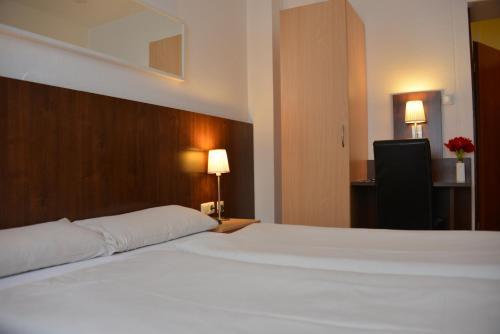 a large white bed in a hotel room at Hotel Italia in Munich