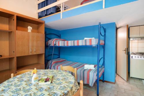 a room with two bunk beds and a table at Monolocale con soppalco 43 in Albenga