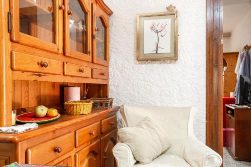 a kitchen with a wooden cabinet and a chair at Gesgroup in Lloret Blau